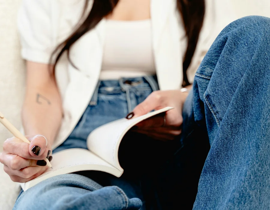 Osoba zapisuje krótkie obserwacje w notesie w spokojnym domowym otoczeniu